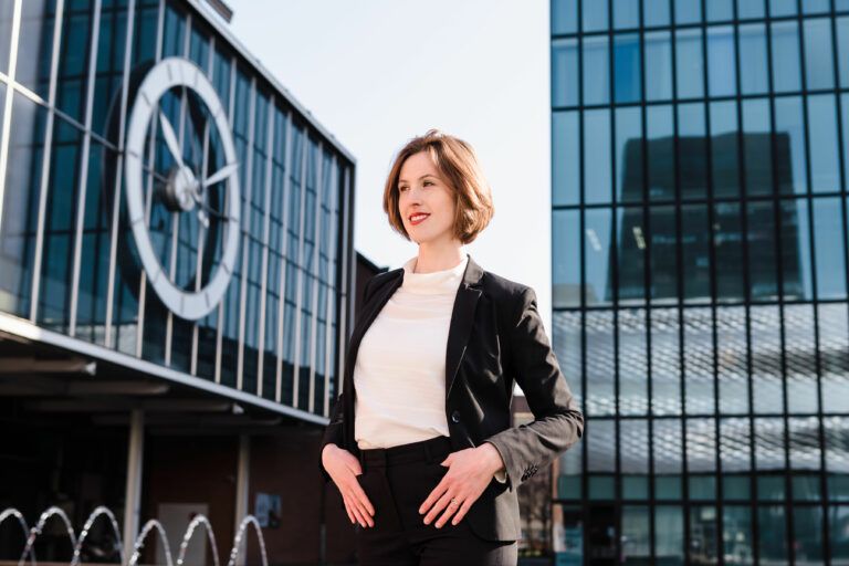 Dame bei Business Shooting mit Uhr im Hintergrund