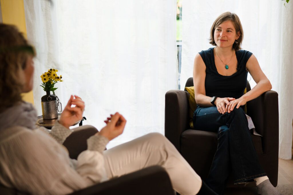 Frau sitzt auf Stuhl bei Interview